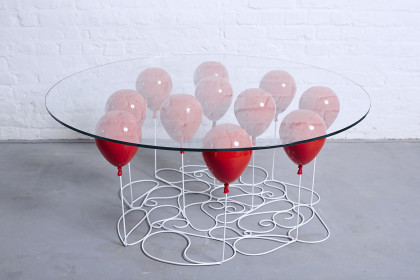 A Glass Desk that Appears to be Held Aloft by Helium Balloons item-thumbnail