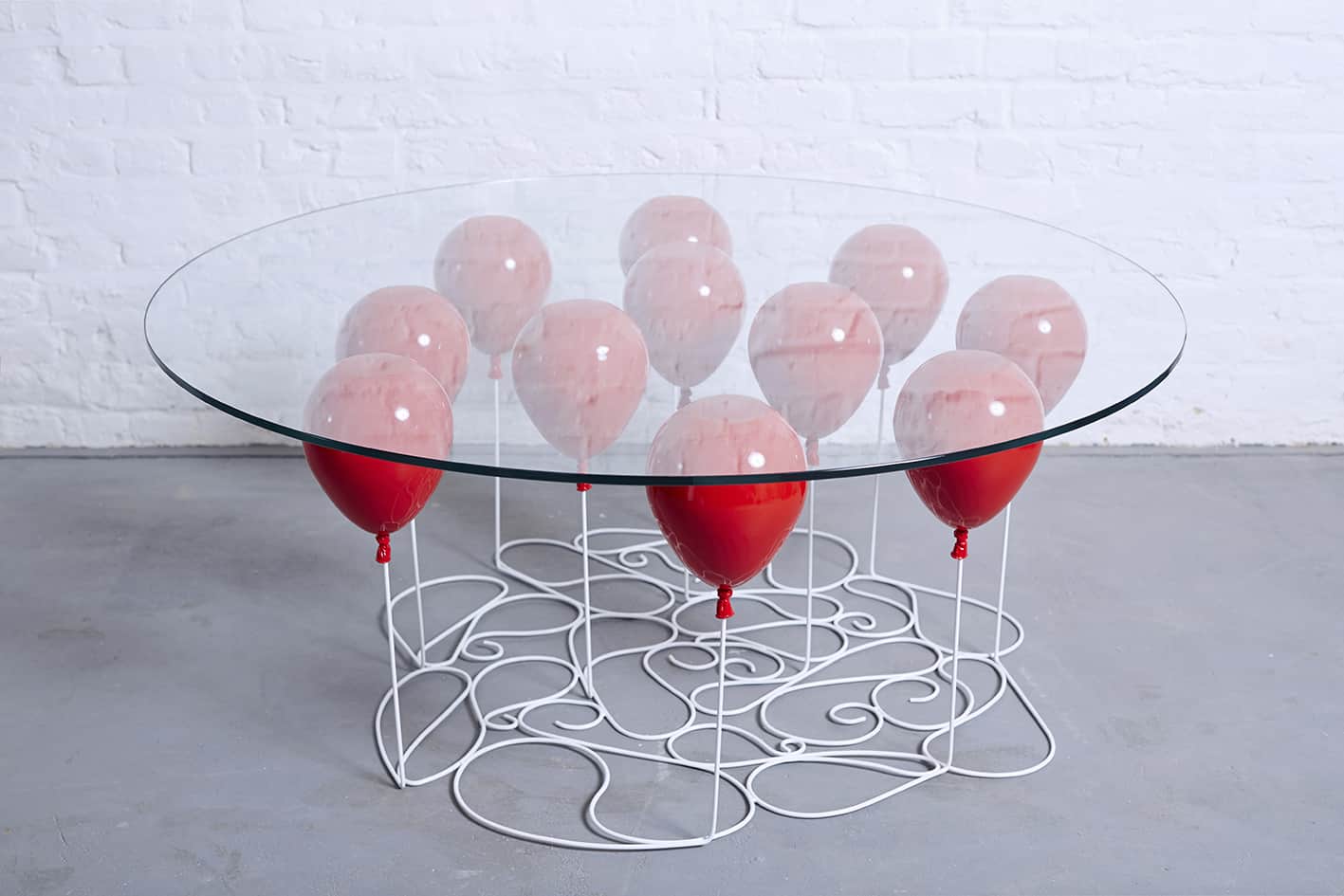 A Glass Desk that Appears to be Held Aloft by Helium Balloons